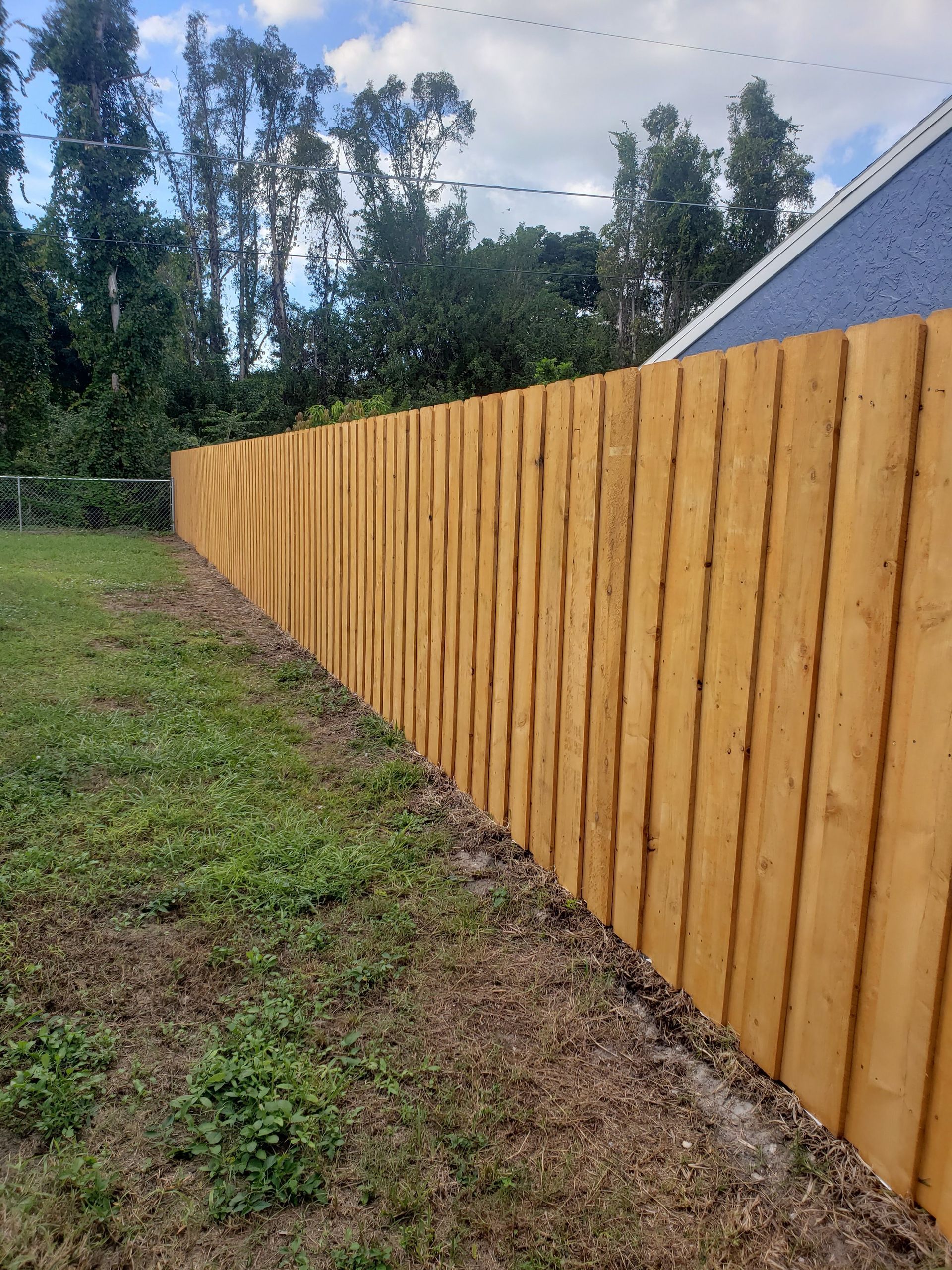 A wooden fence is sitting in the middle of a grassy field.