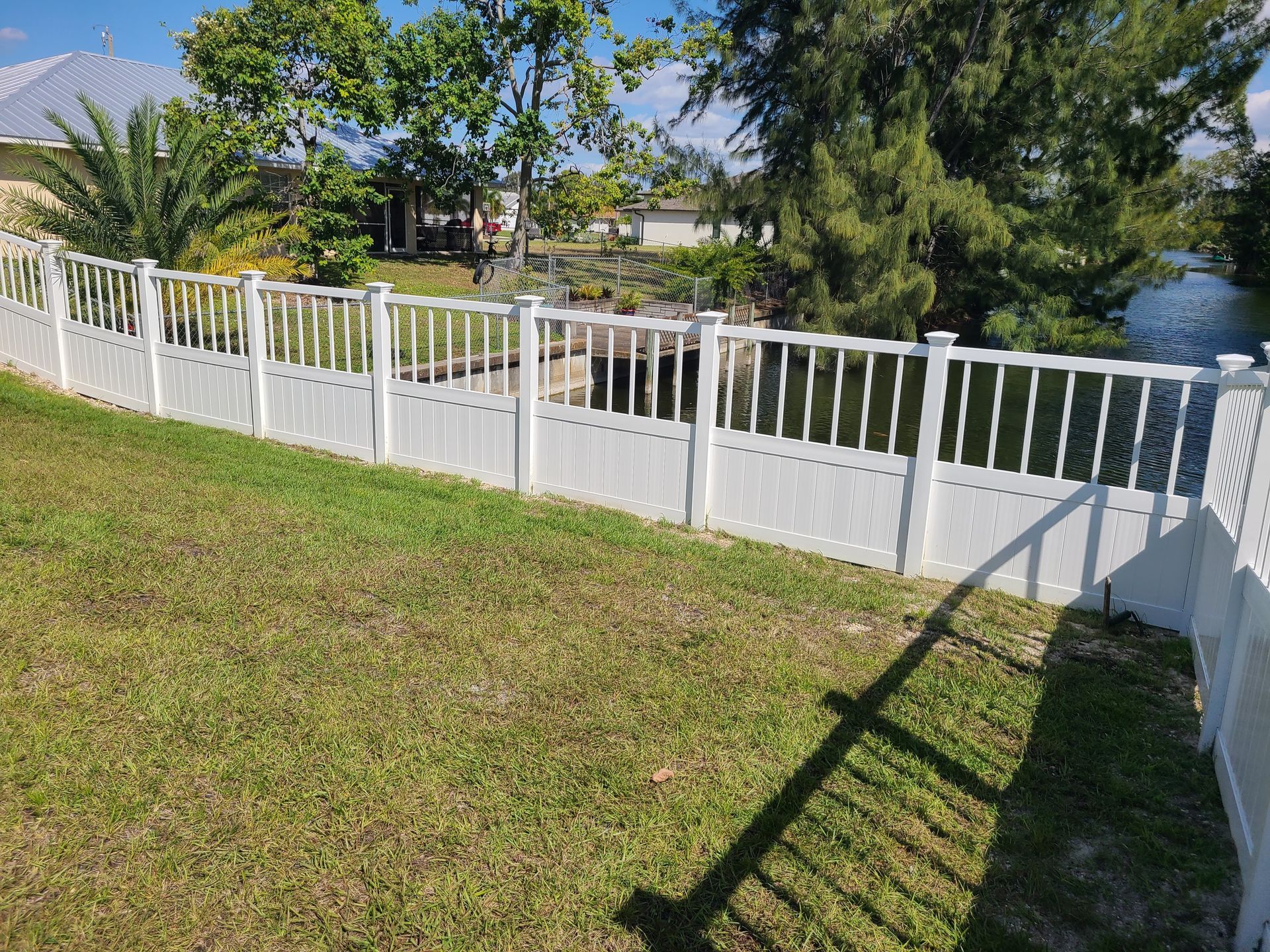 A white fence is sitting on top of a lush green lawn.