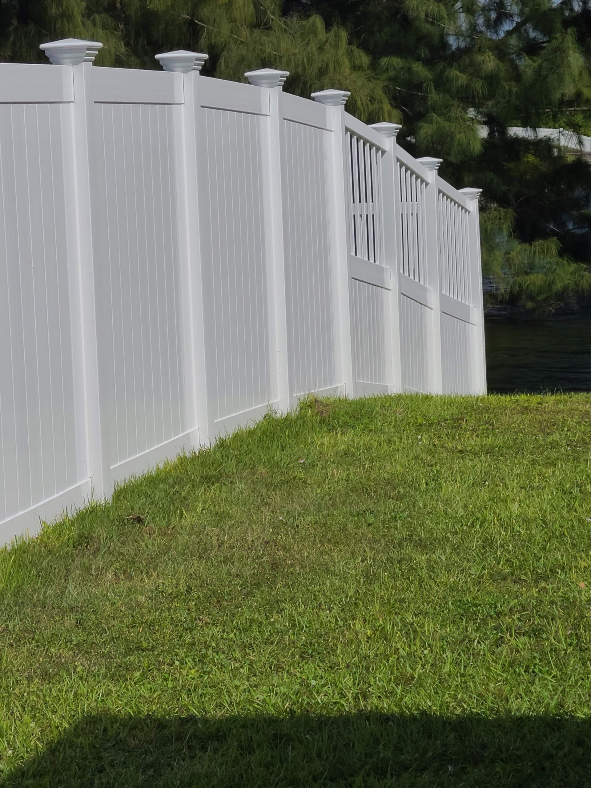 A white fence surrounds a lush green lawn.