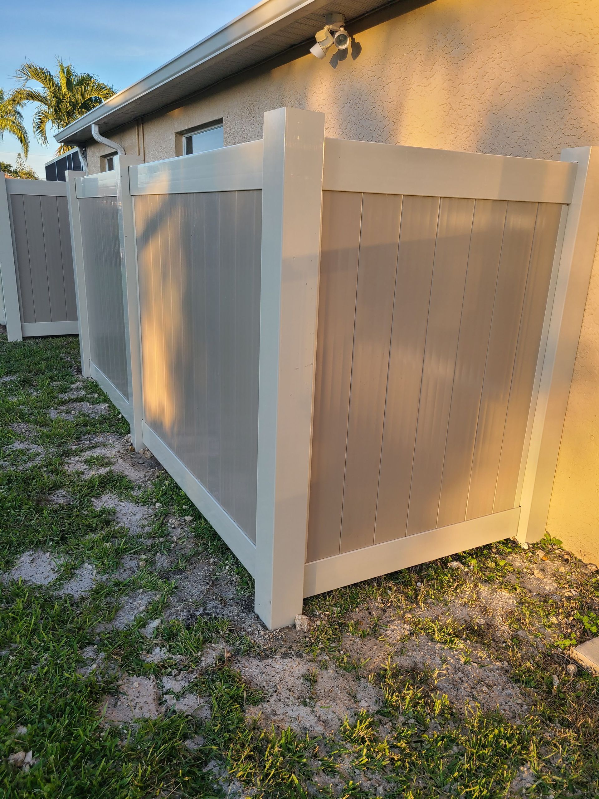 A white fence is sitting in front of a house.