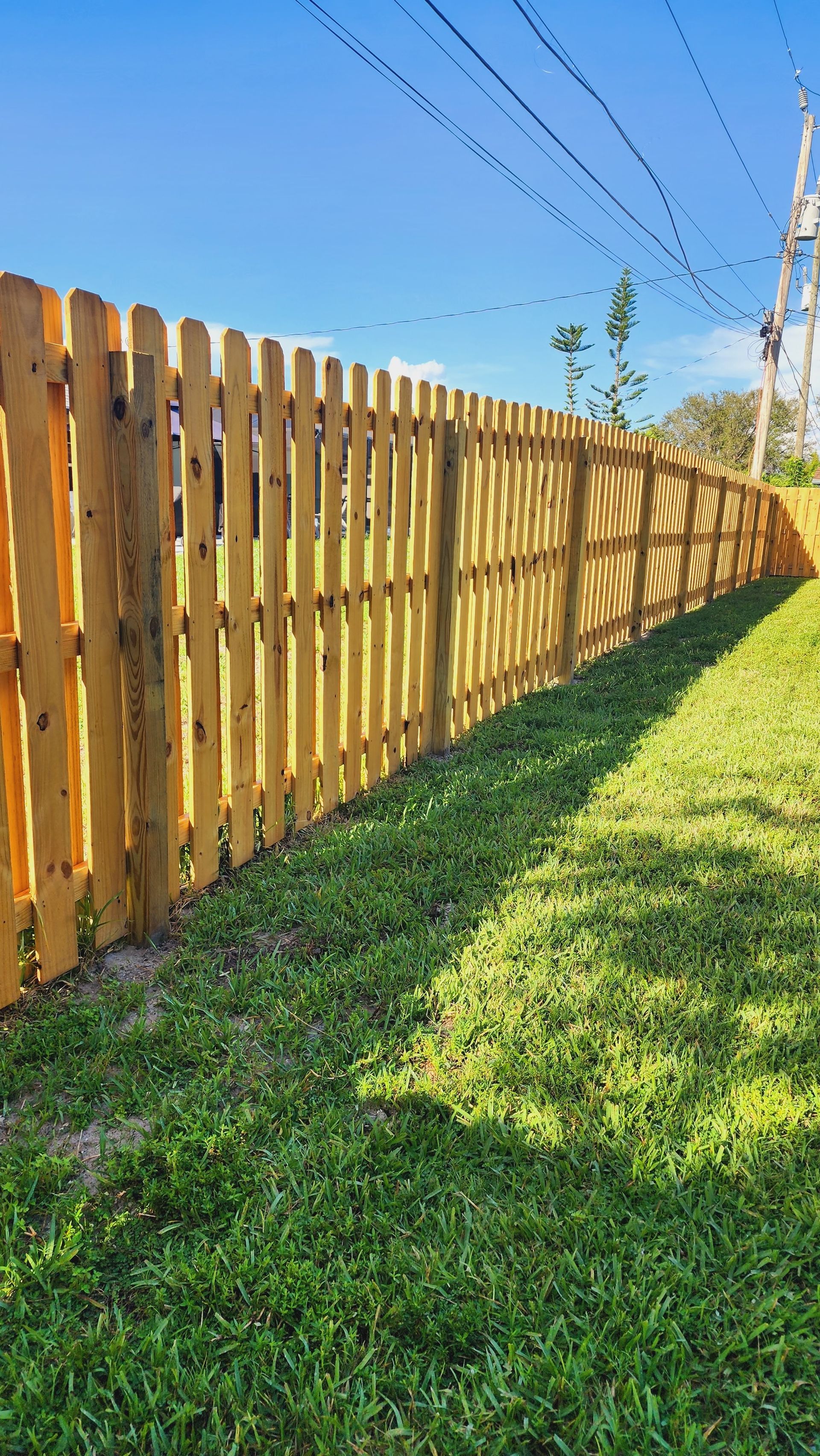 A wooden picket fence surrounds a lush green yard.