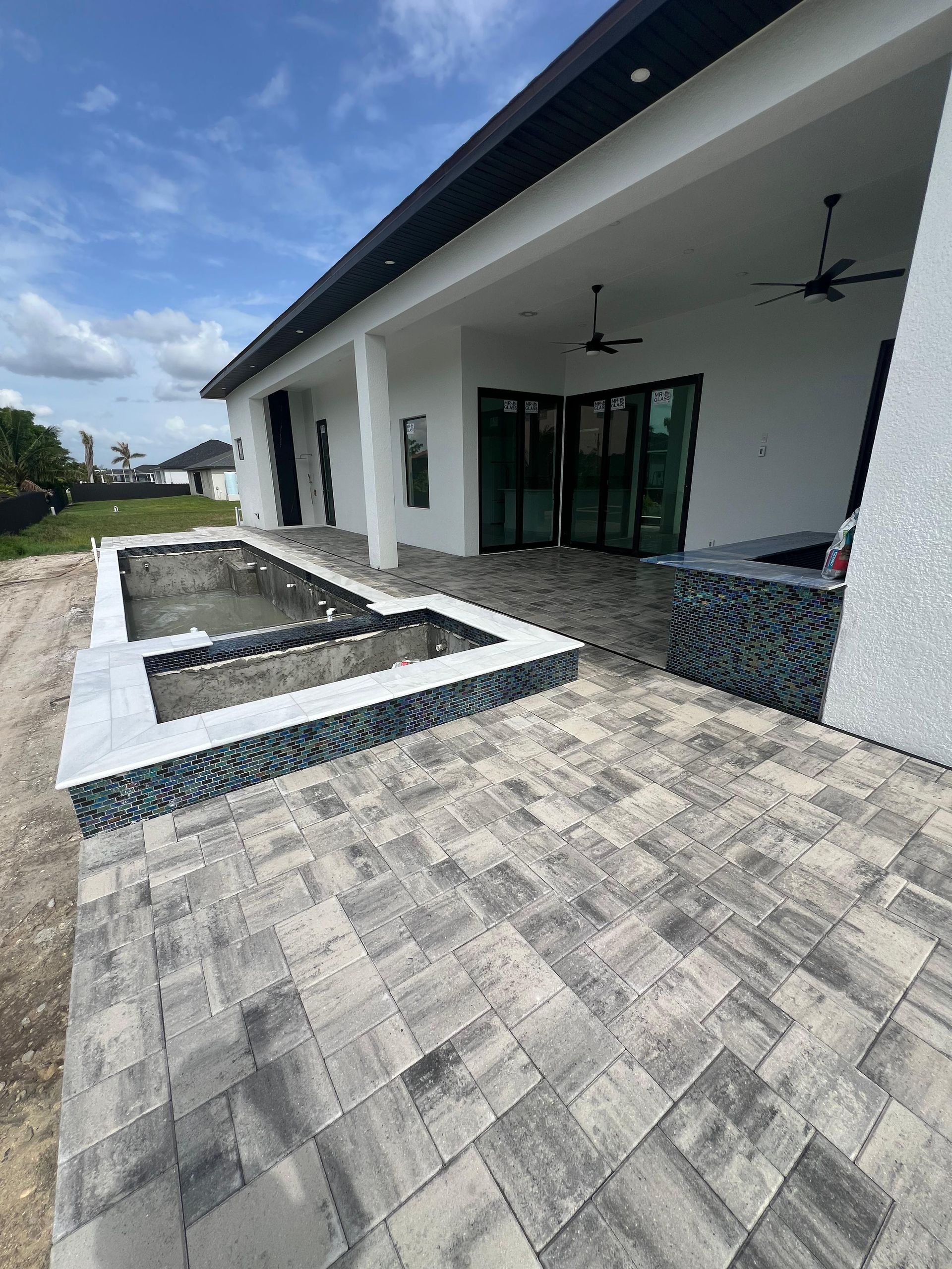 Backyard with a pool under construction, featuring a patio, and a covered porch.
