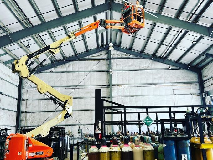 technician in a lift in a warehouse