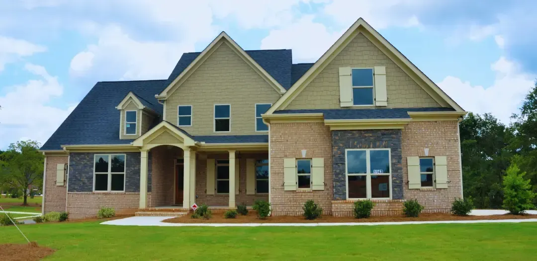 A large brick house with a blue roof and white shutters