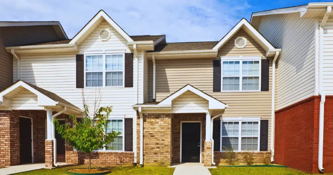 A large house with a lot of windows and a brick wall.