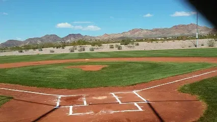 A baseball field with mountains in the background on a sunny day.