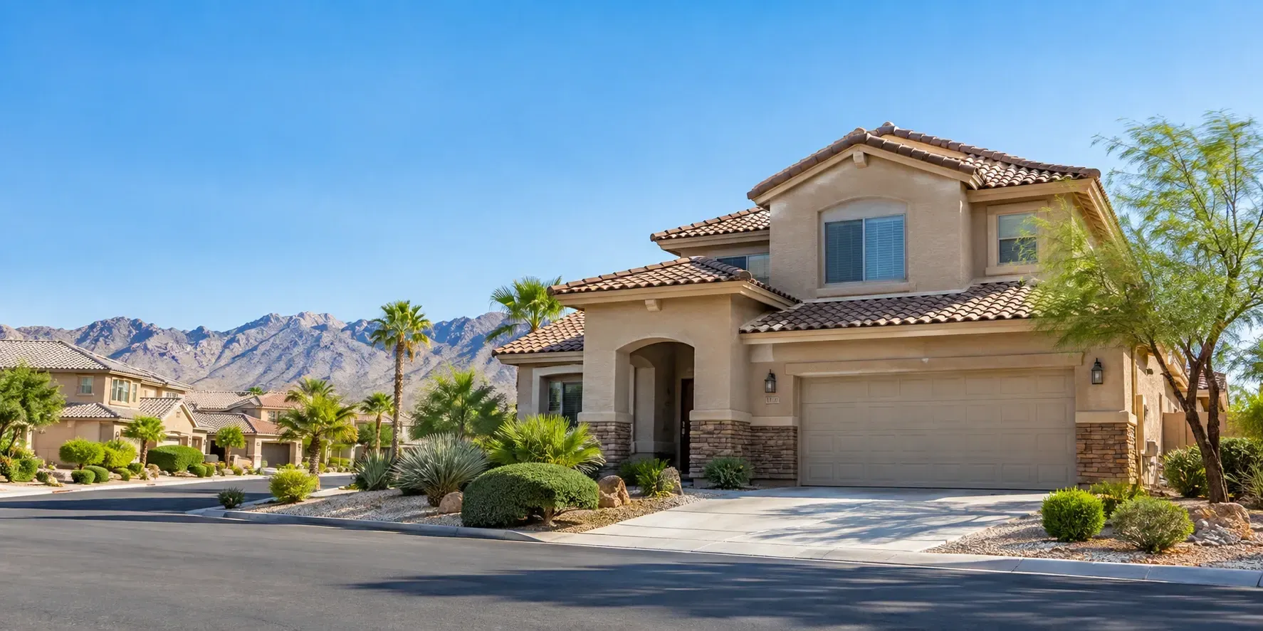 Sunny stucco home in a Las Vegas neighborhood with desert landscaping and mountains nearby.