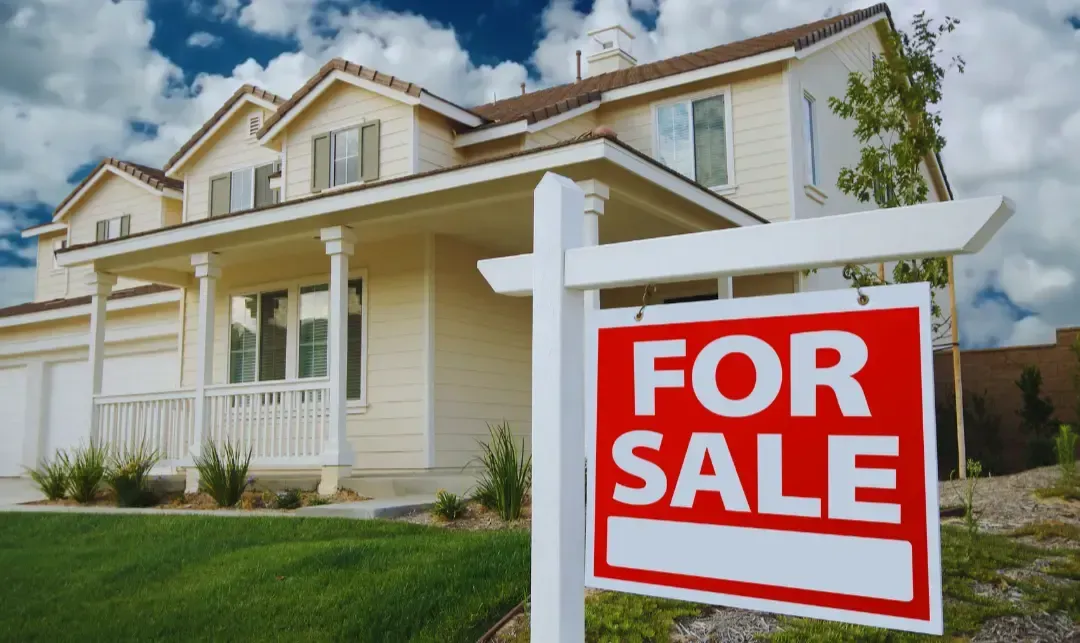 A house with a for sale sign in front of it