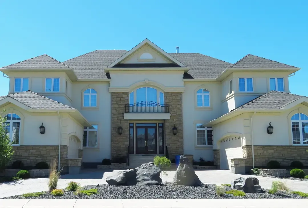 A large white house with a gray roof and a lot of windows