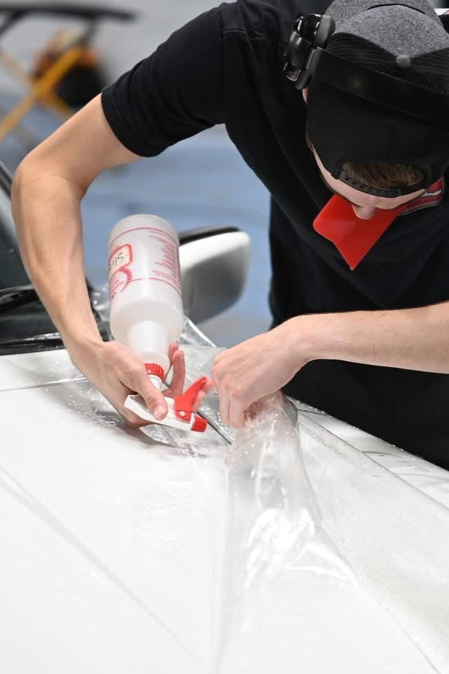 Person in black shirt using a tape dispenser to seal a white package on a table