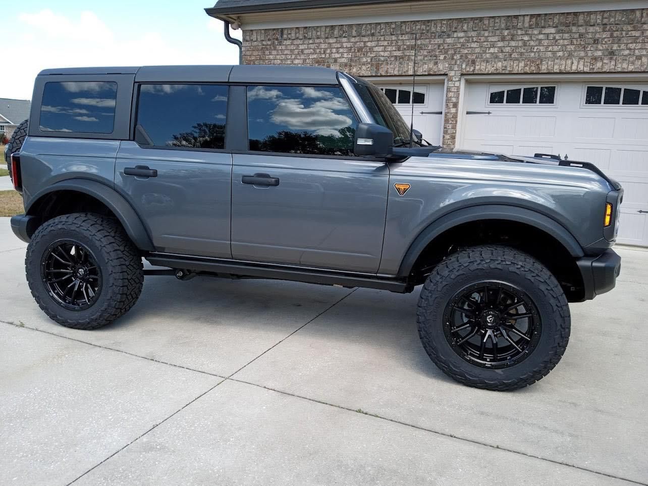 A ford bronco is parked in front of a garage after window tinting