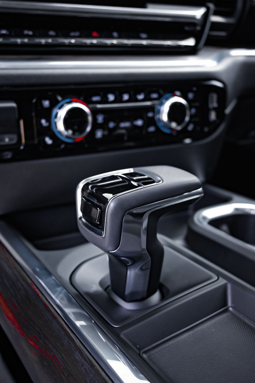Close-up of a modern car center console with a gear shifter and climate controls.