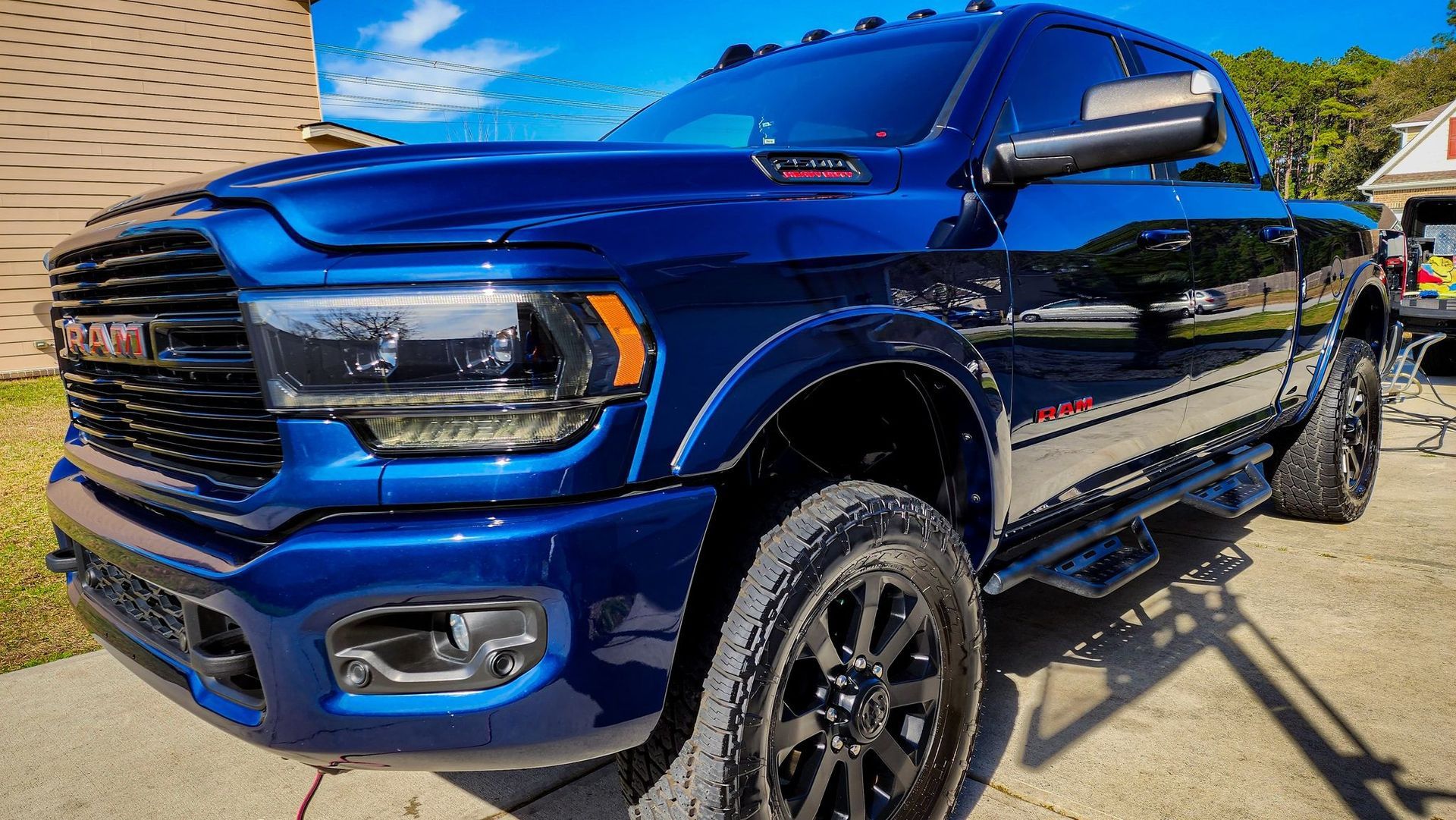 Blue pickup truck parked outdoors on a sunny day, front-left view.