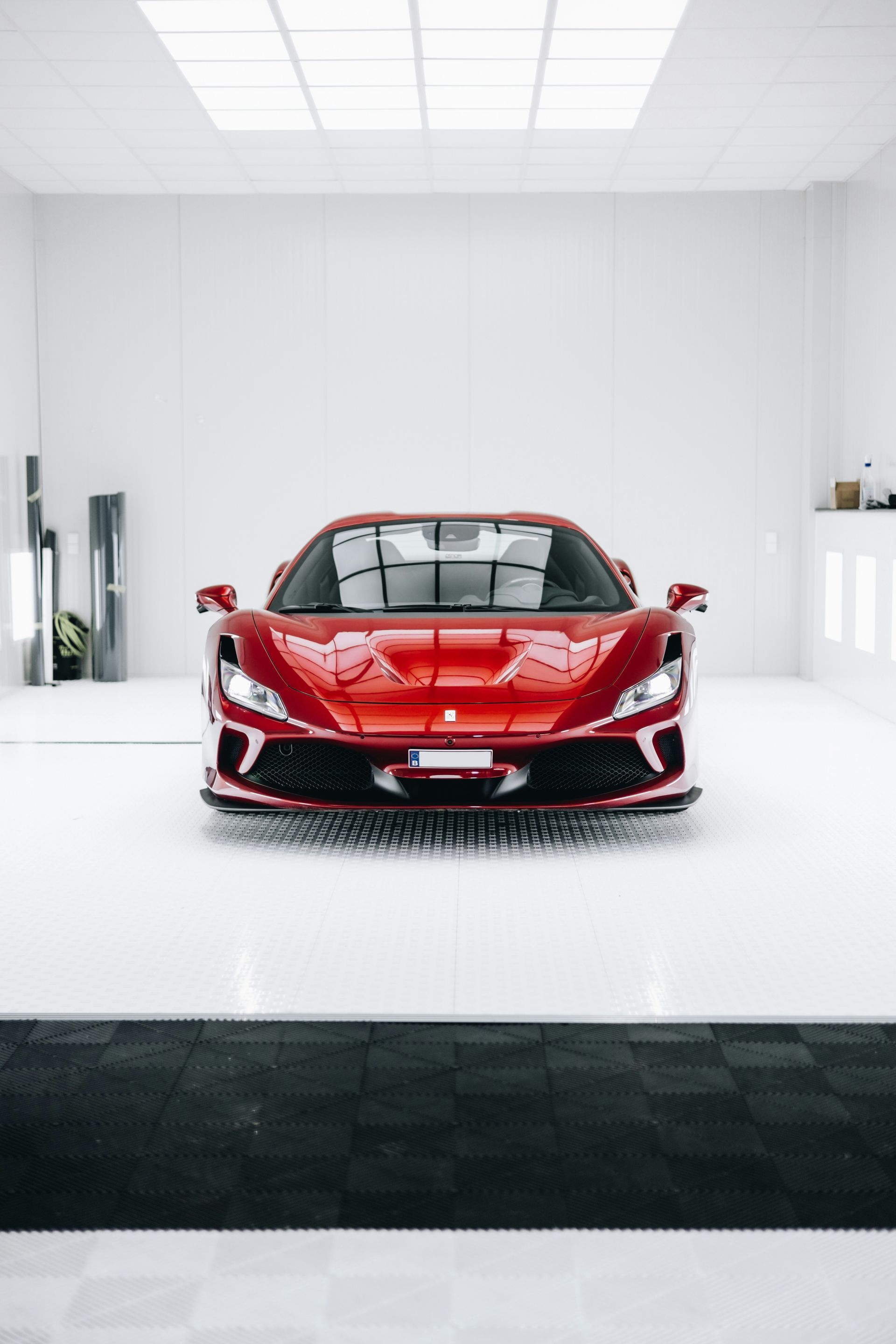 Red sports car centered in a bright white showroom