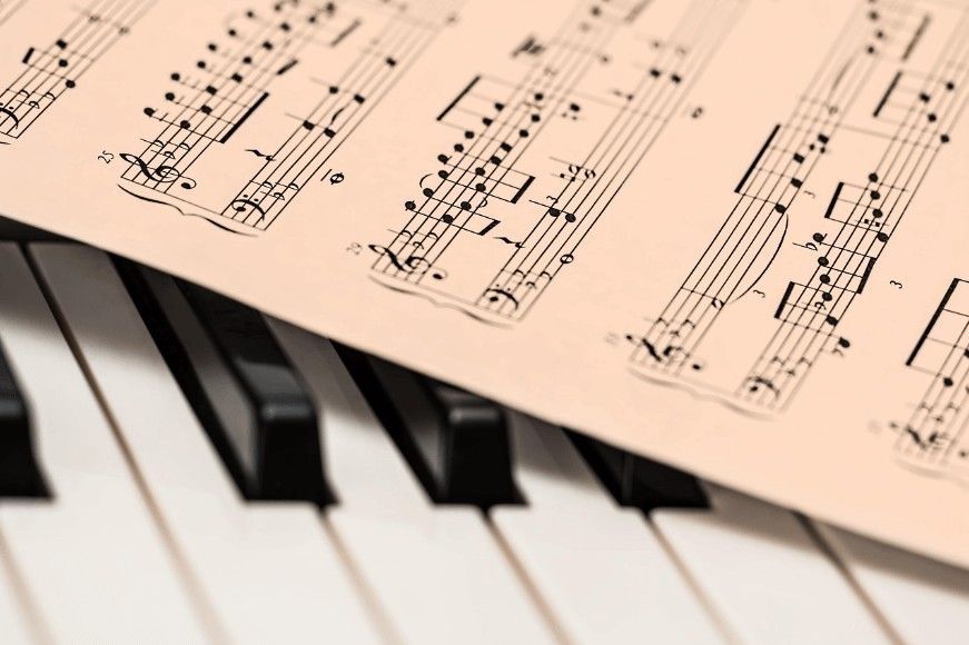 A close-up of piano keys with sheet music draped across them creates a gentle, reflective mood with cremation services in Chaska, MN