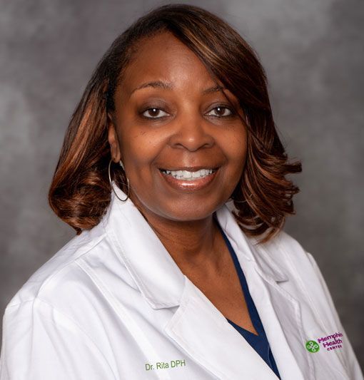 Smiling medical professional in a white coat with a gray studio background