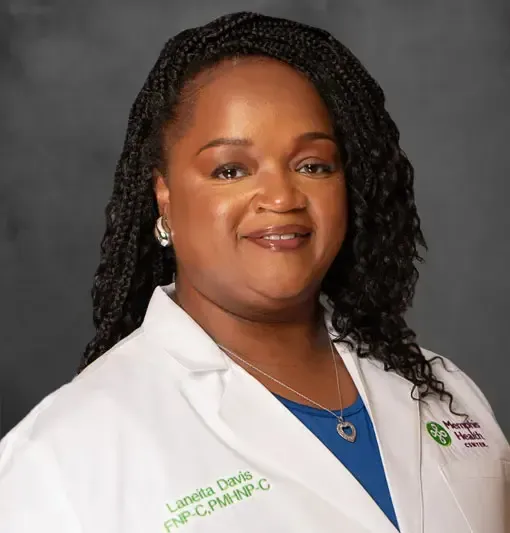 Portrait of a woman in a white lab coat against a gray studio background