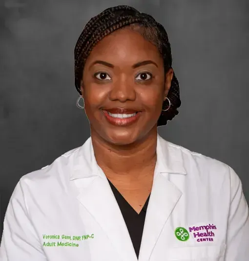 Portrait of a smiling doctor in a white lab coat against a gray studio backdrop