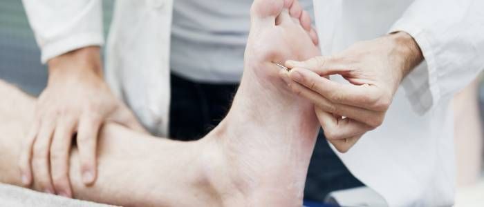 Hands massaging a bare foot during a treatment session