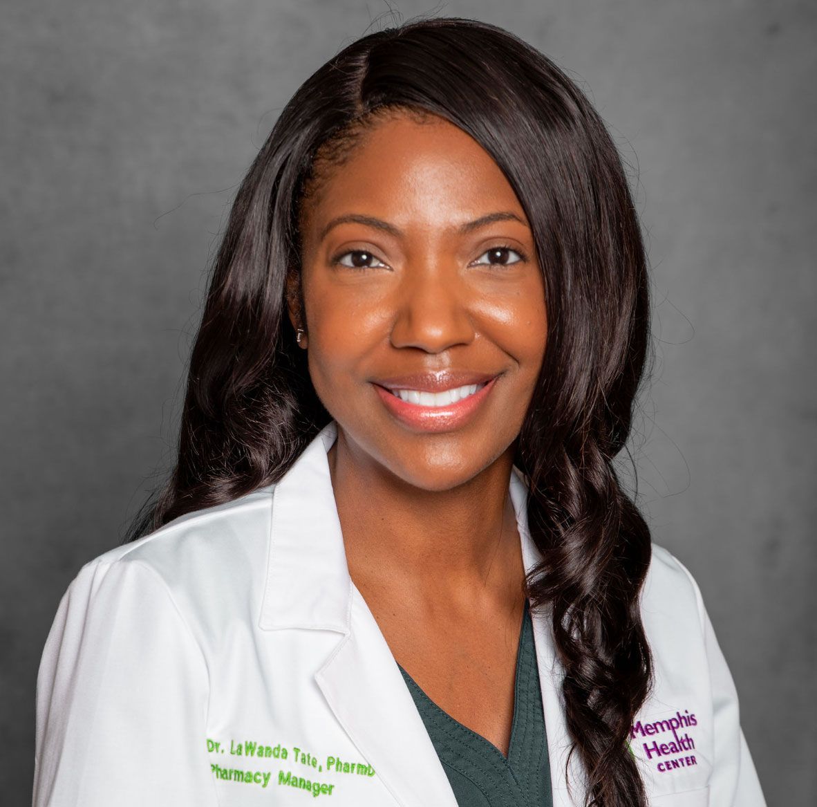 Portrait of a smiling doctor in a white lab coat against a gray background