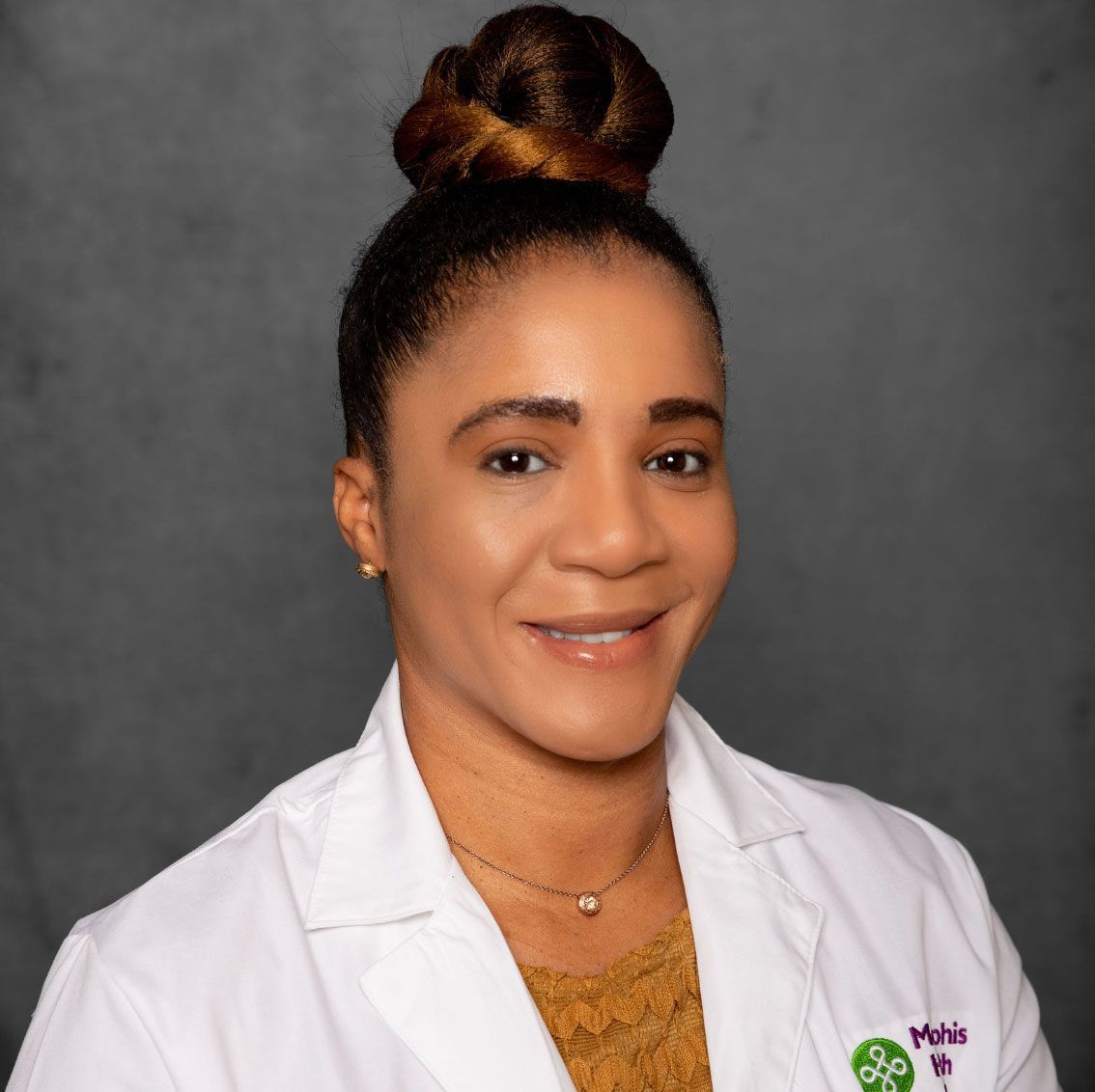 Portrait of a smiling professional in a white coat against a gray background