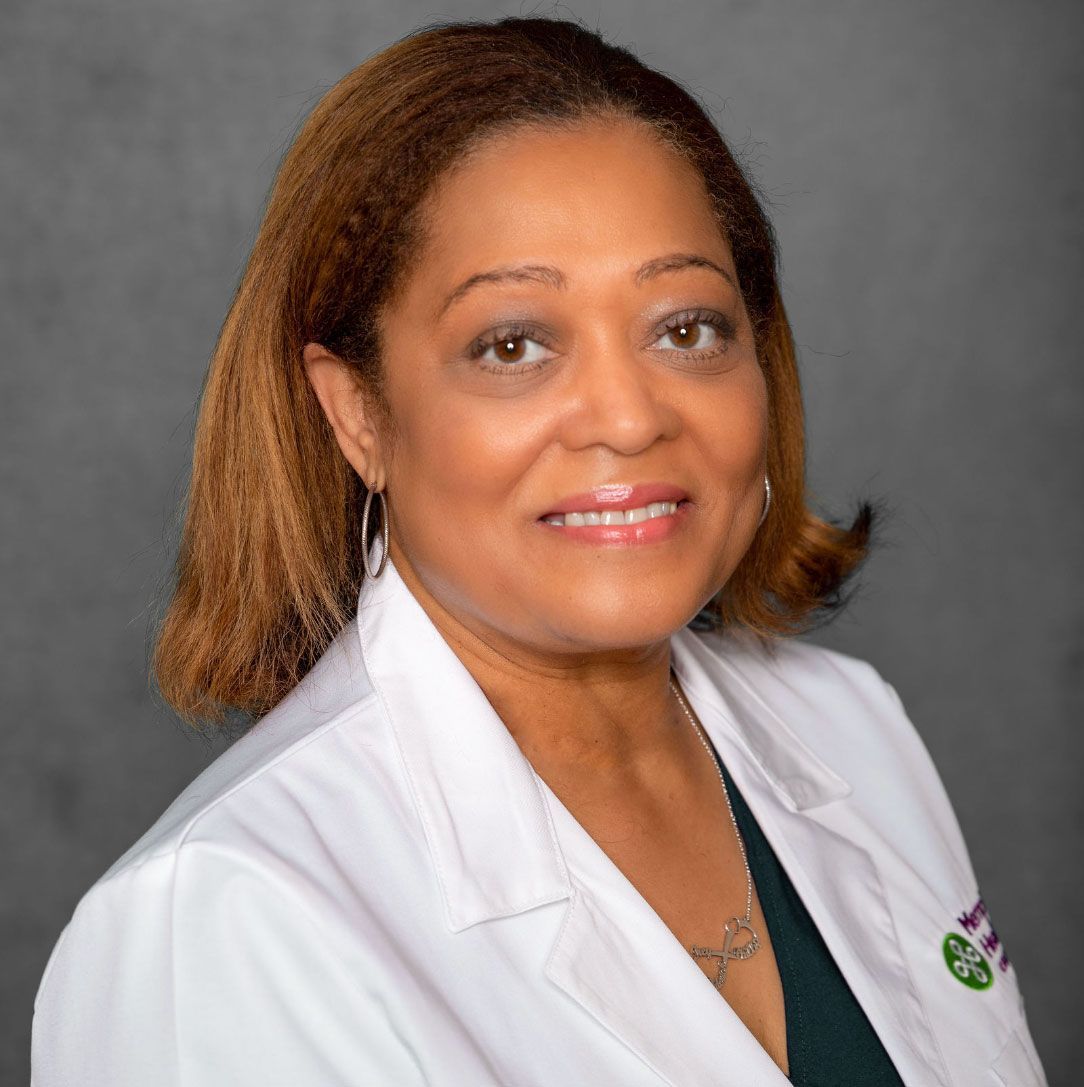 Portrait of a smiling medical professional in a white coat against a gray background