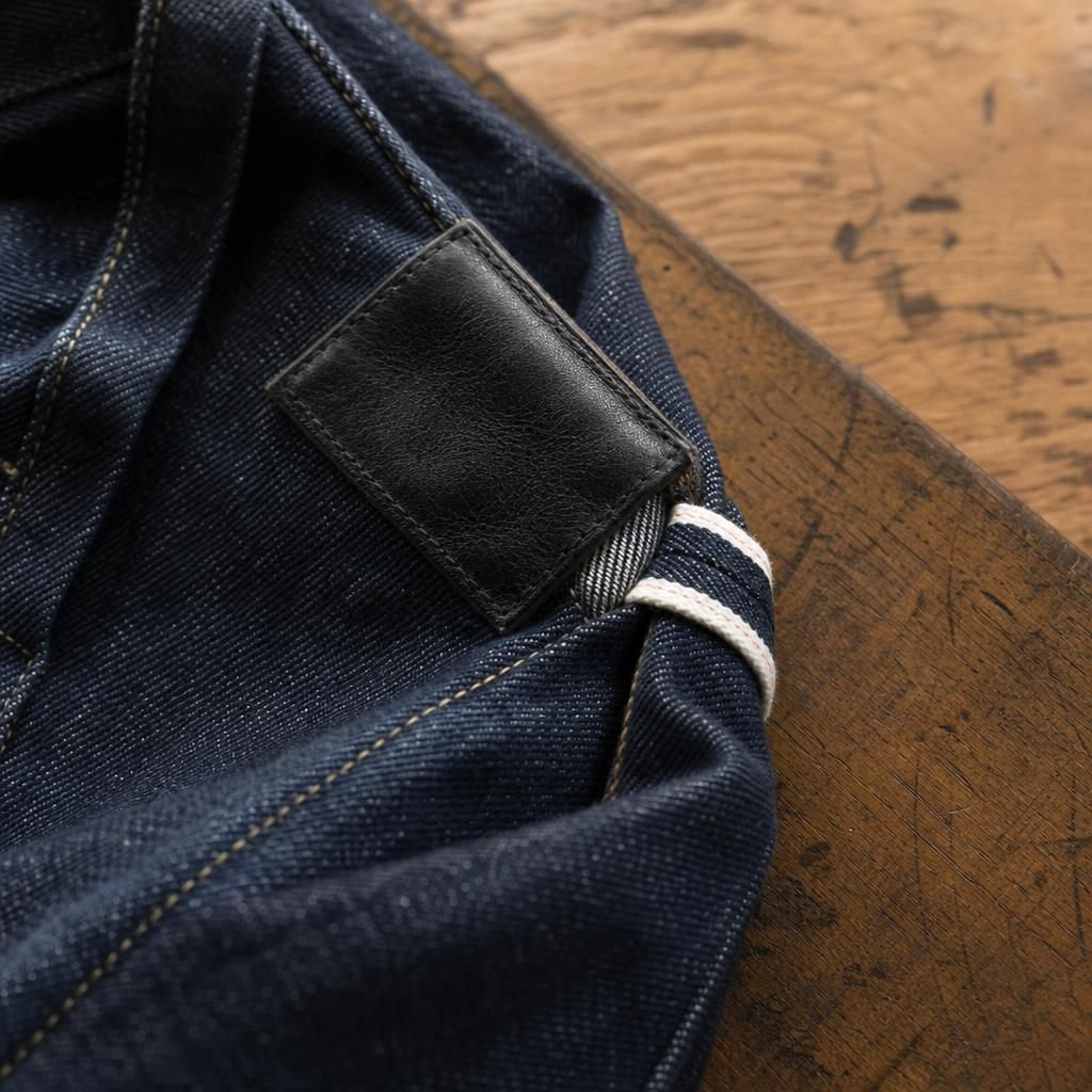 Close-up of indigo denim texture and stitching on wood table