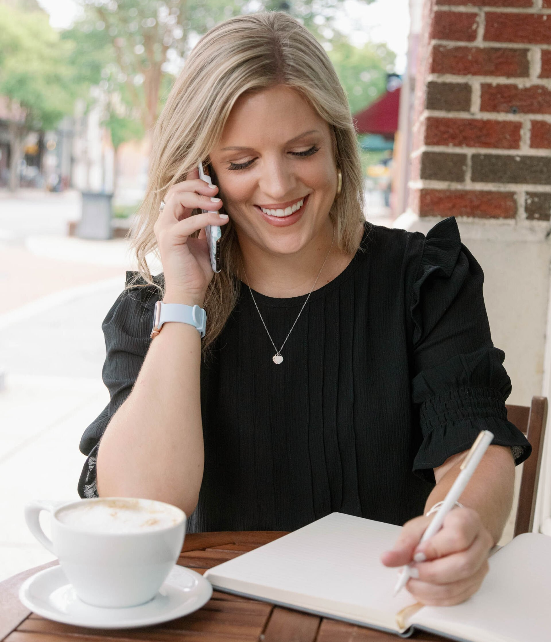 Leigh making notes at an outdoor cafe