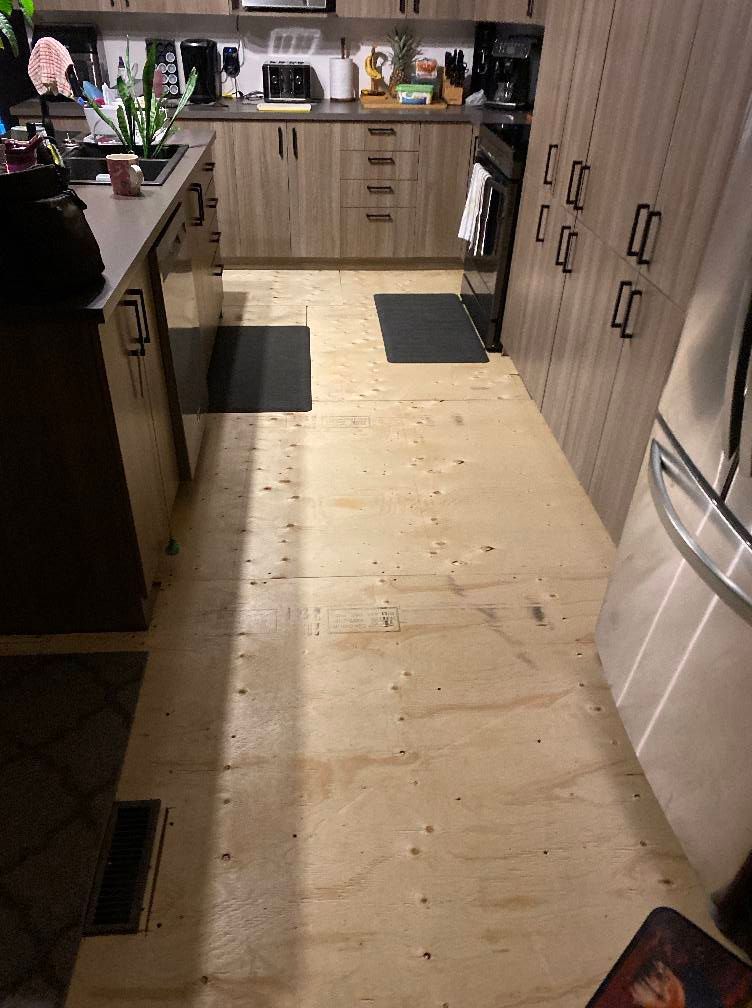 Une cuisine avec un plancher en bois et des appareils en acier inoxydable