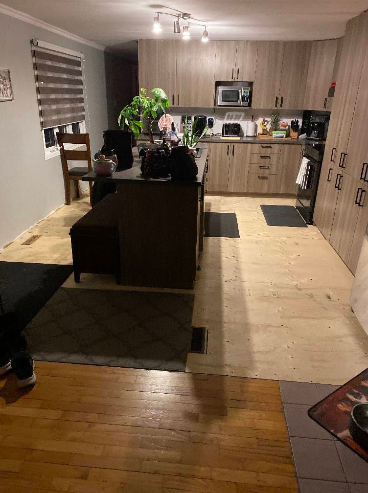 Une cuisine avec des armoires en bois et un plancher en bois.