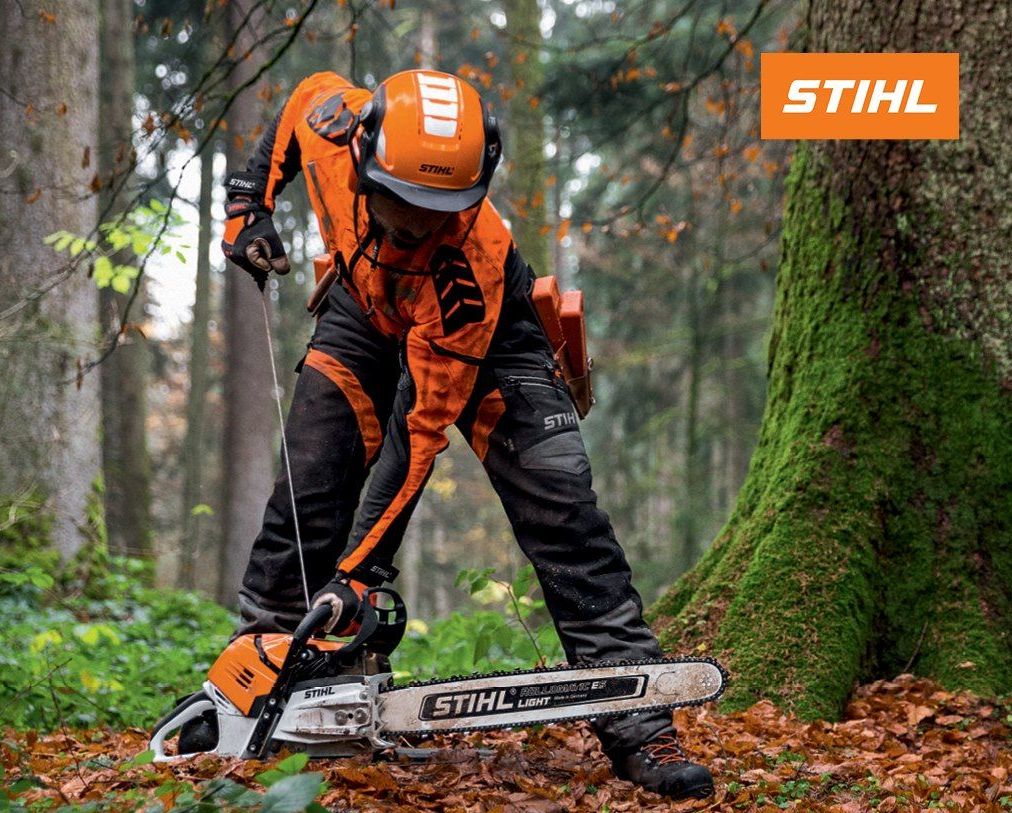 A person in safety gear operates a STIHL MS 500i chainsaw in a forest setting.