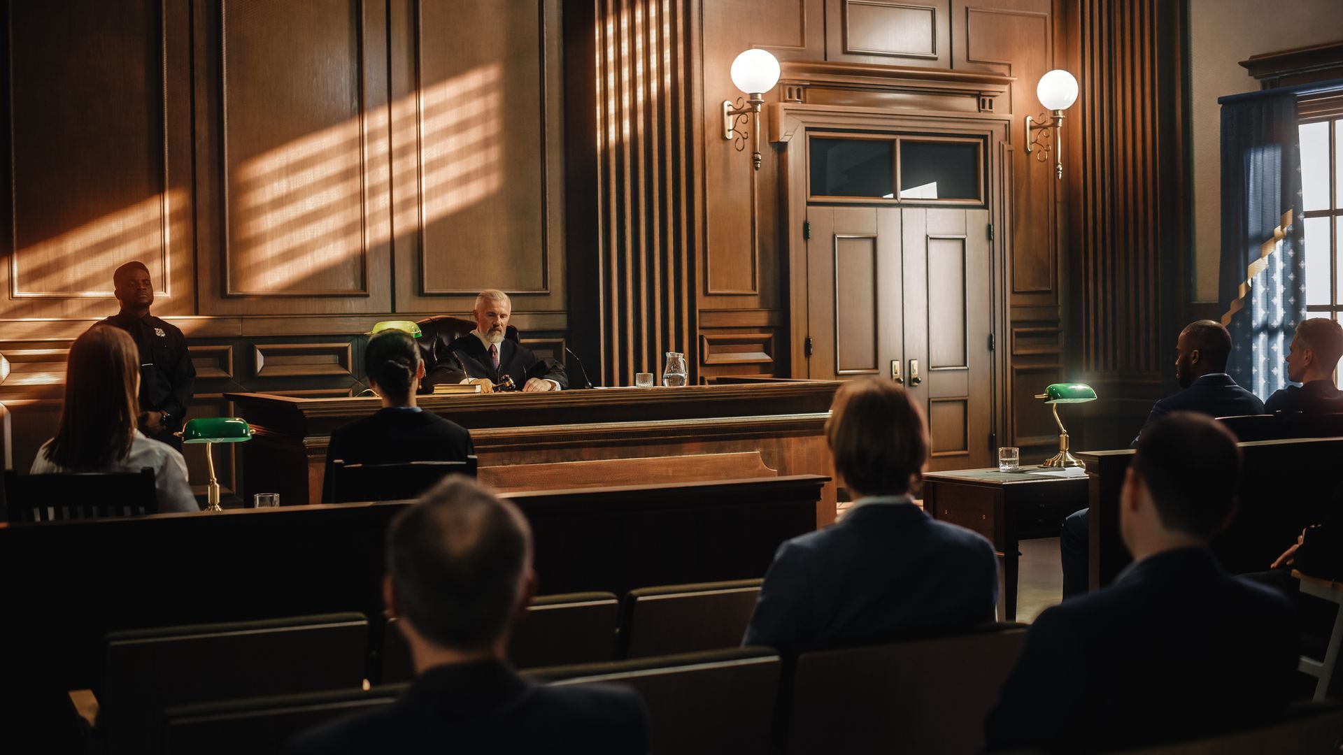 a group of people are sitting in front of a judge in a courtroom .