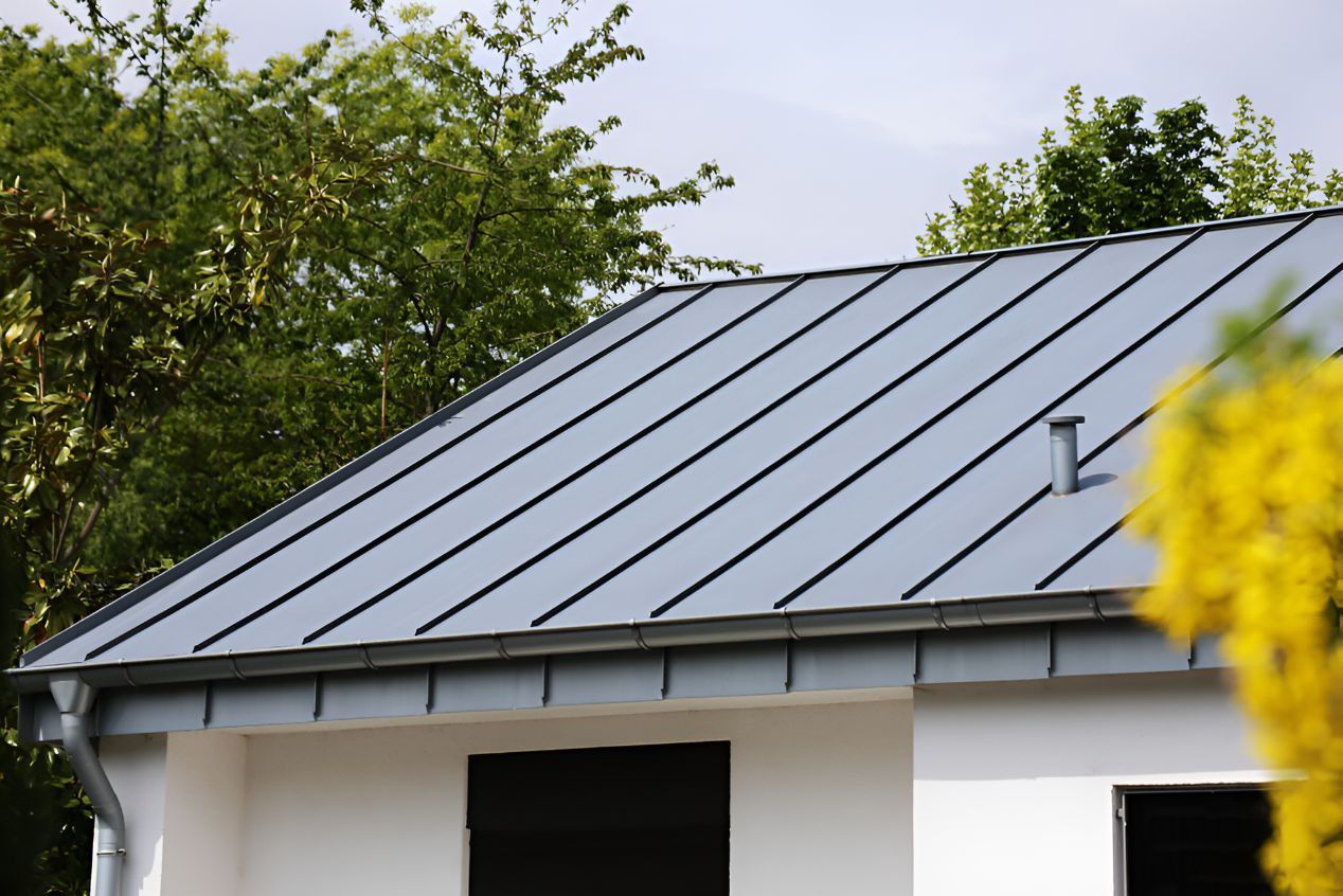 A House With a Metal Roof and a Yellow Flower in the Foreground — Goonellabah Roof Tilers in Bangalow, NSW