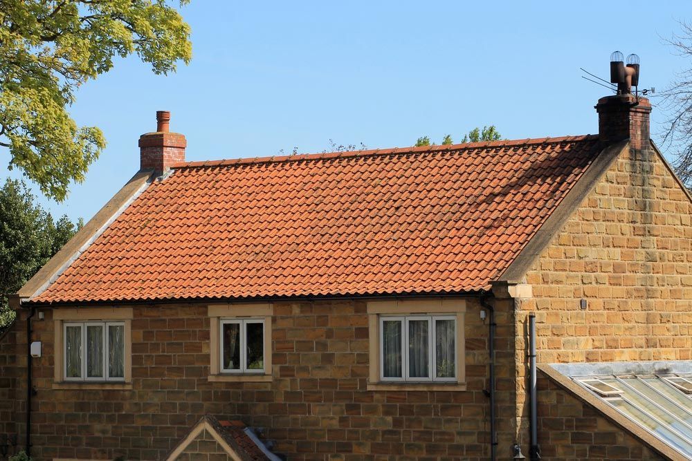 Exterior of Brick House with Red Roof Tiles — Goonellabah Roof Tilers In Tweed Heads, NSW