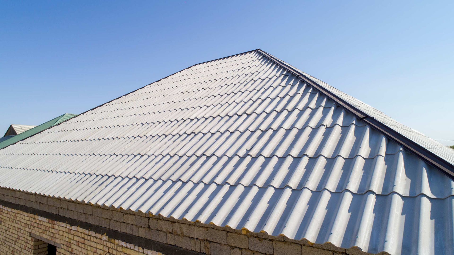 White Corrugated Metal Roof on A Building Under a Clear Blue Sky — Goonellabah Roof Tilers In Northern Rivers, NSW
