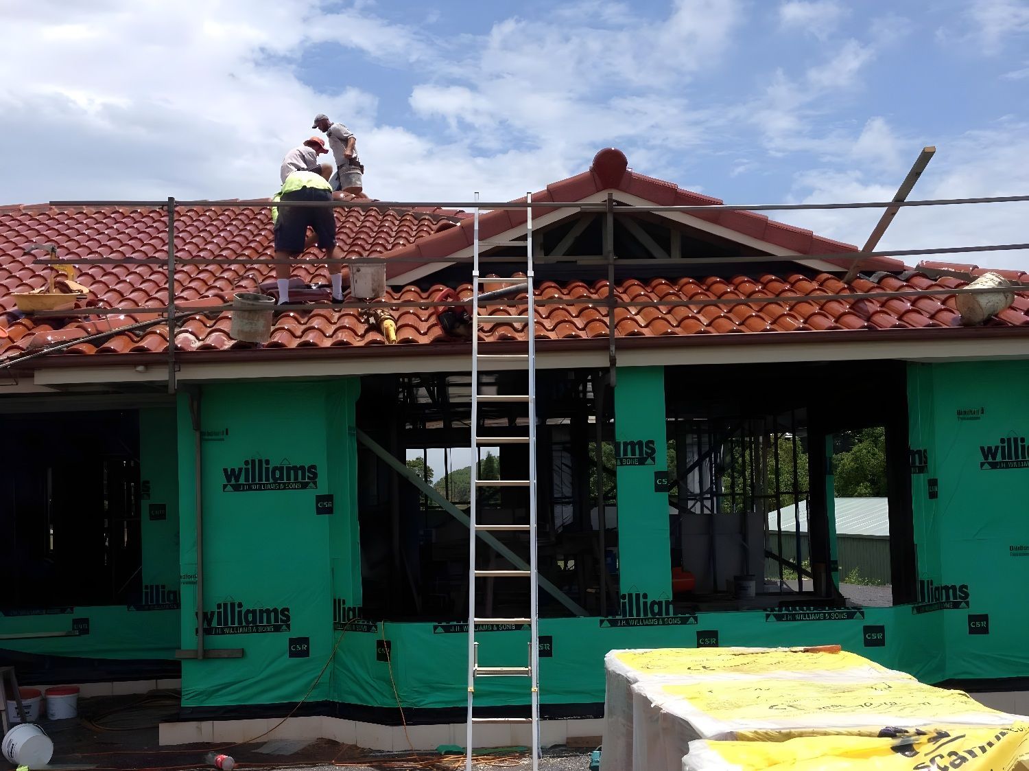 Roofers Inspecting And Repairing Tiled Roof After Storm Damage