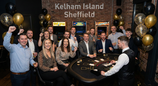 Corporate party guests enjoying an Ace Party blackjack table with arcade games and black and gold balloon décor in Sheffield