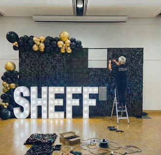 Ace Party premium black and gold event styling with sequin wall and light-up letters being built in Sheffield