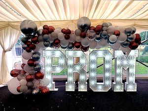 Prom light up letters with balloon garland display inside a venue for school prom in South Yorkshire