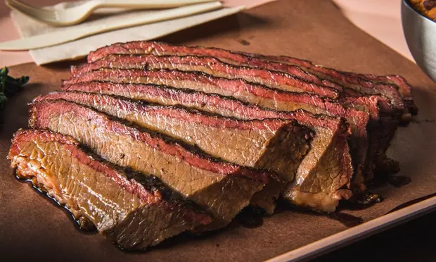 A large piece of meat is sitting on a cutting board.