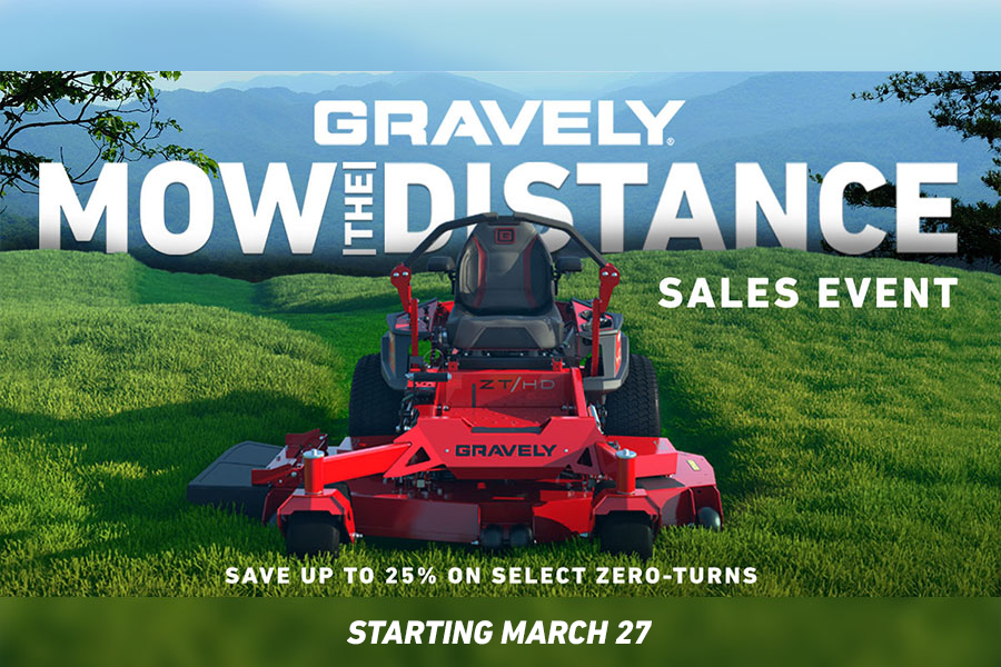 a red and black lawn mower is parked in front of a house .