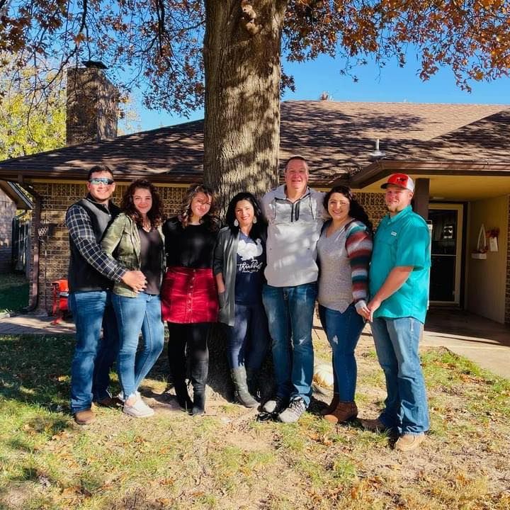 Un grupo de personas posando para una foto frente a una casa