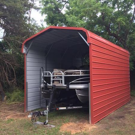 Un barco está estacionado en un cobertizo de metal rojo.
