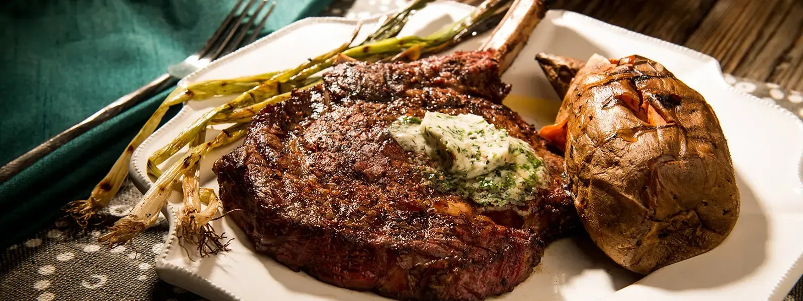 A white plate topped with a steak , asparagus and a potato.