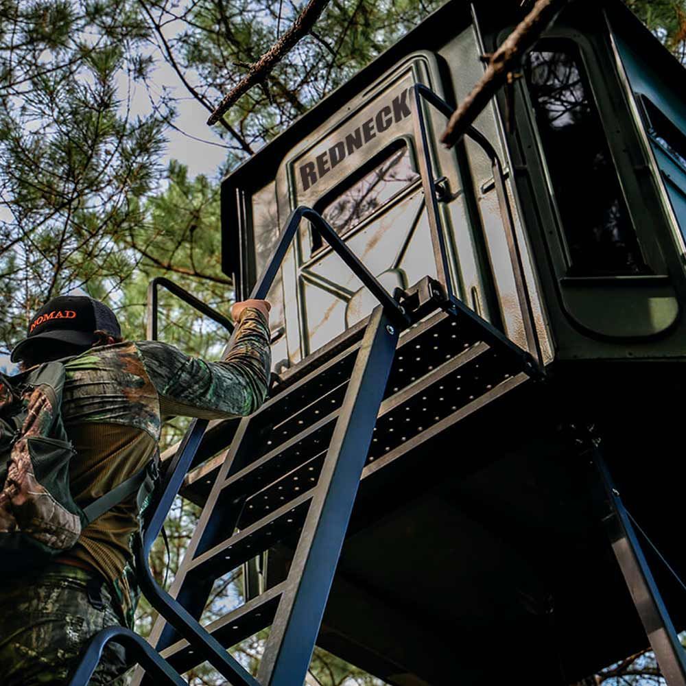 a man wearing a nomad hat climbs a ladder to a redneck cabin