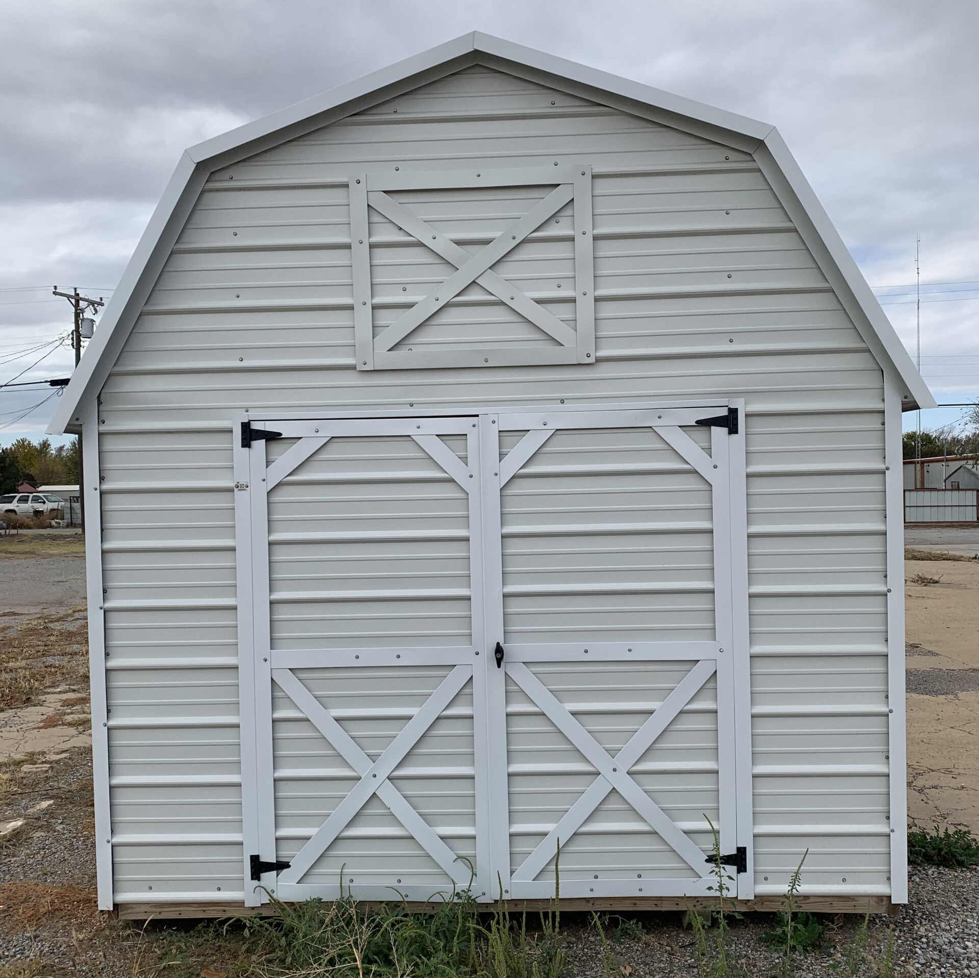 A white Lofted barn with a cross on the top of it