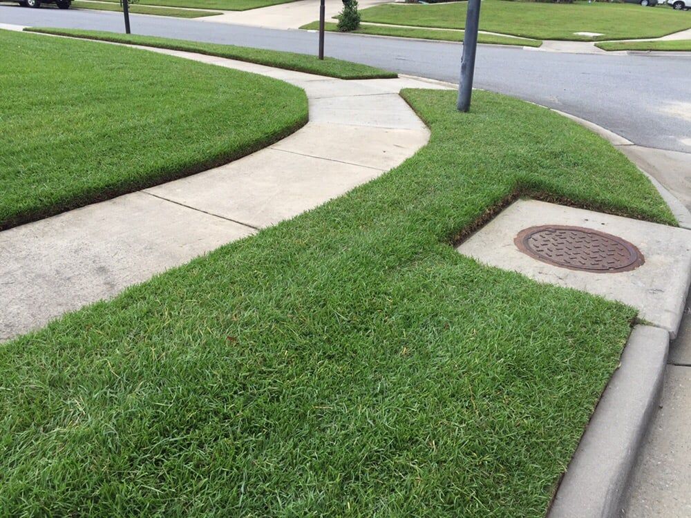 A sidewalk with a manhole cover on the side of it