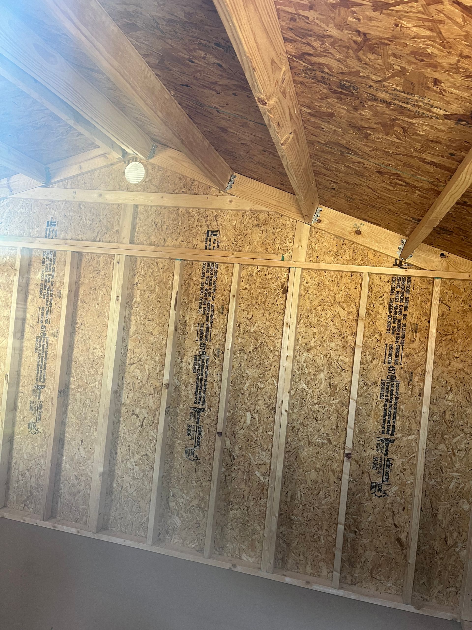 A room with a wooden ceiling and a light on the ceiling.