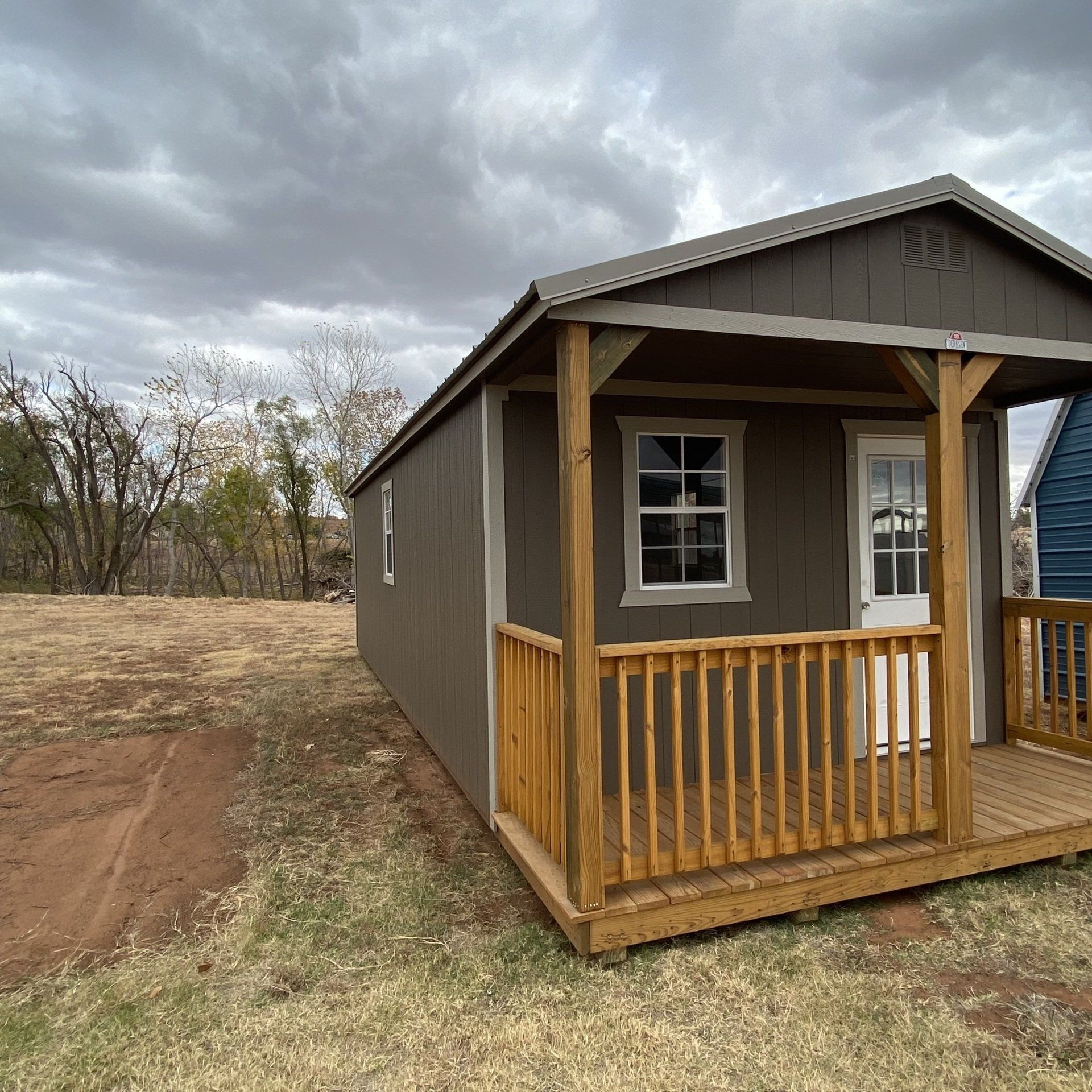 A small house with a porch and a wooden railing