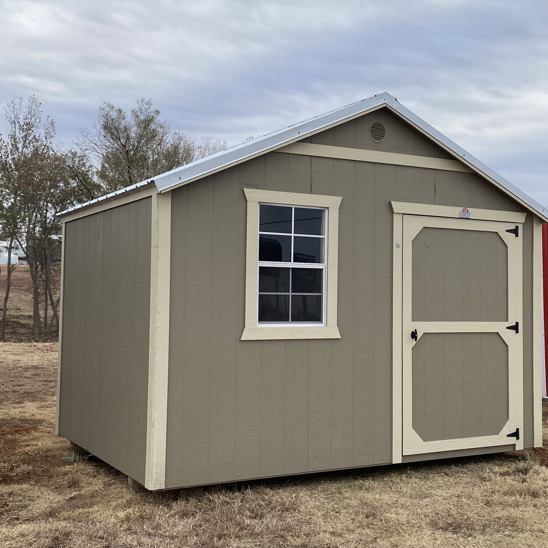 Un pequeño cobertizo con una puerta blanca y una ventana